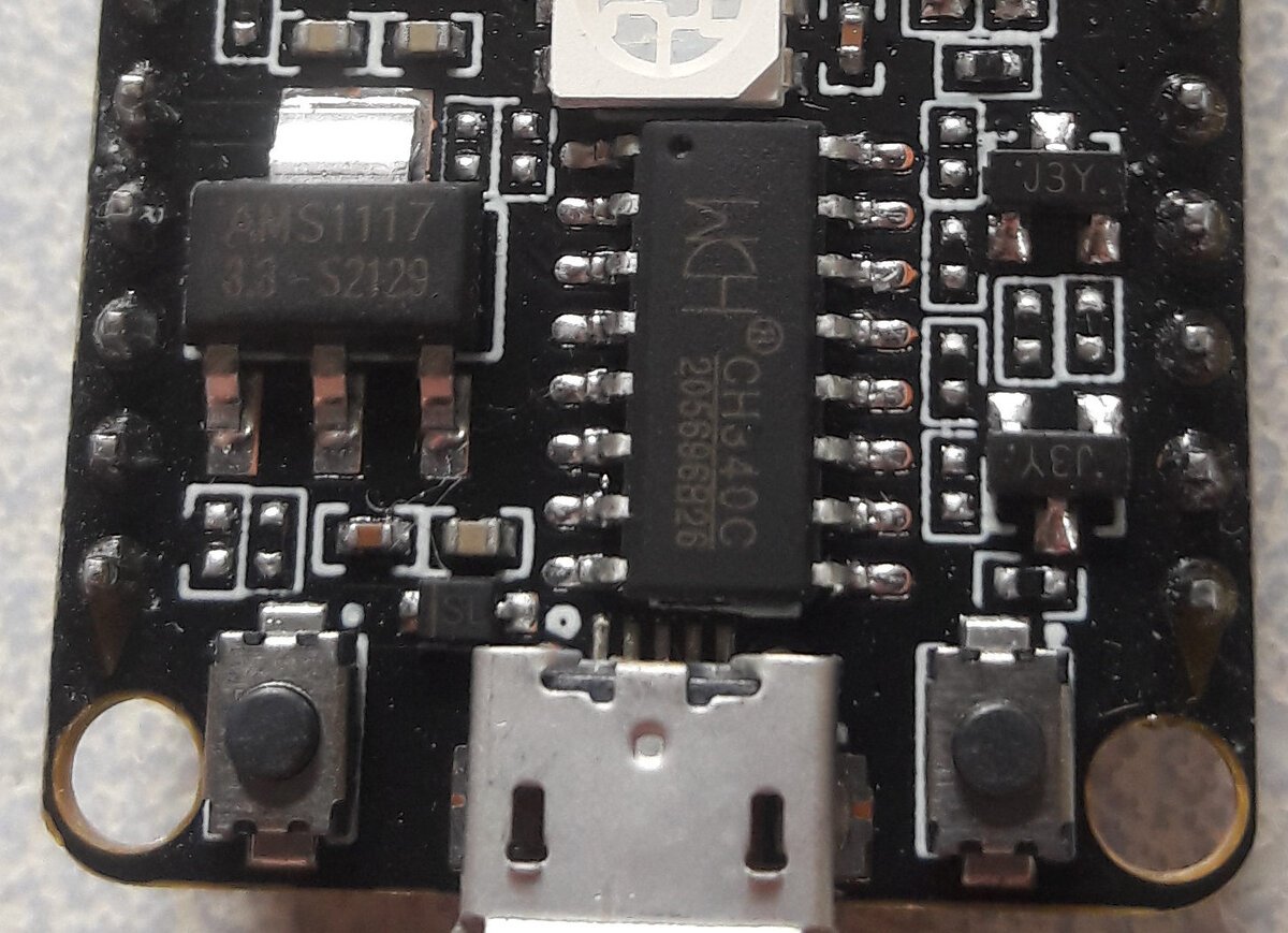 Detalhe de placa ESP32-C3 mostrando o chip conversor USB-serial WCH CH340C ao lado do conector micro-USB
