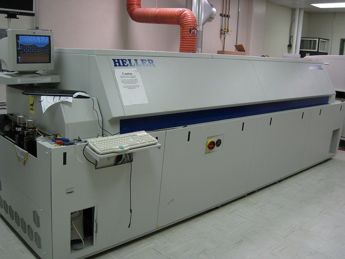 Forno de refluxo industrial de convecção usado em linha de montagem SMT, com a esteira de entrada e o painel de controle do perfil térmico