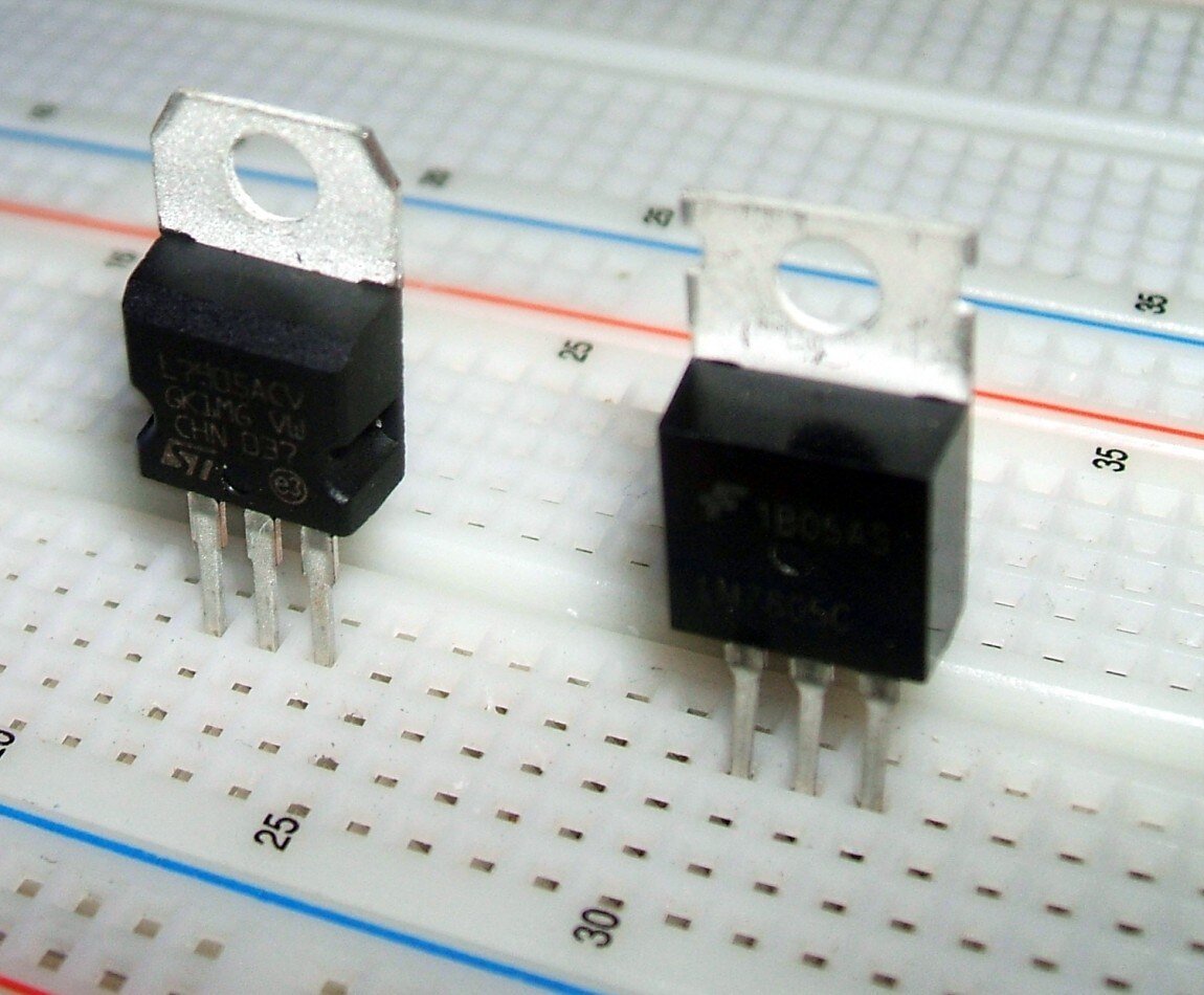 Dois reguladores de tensão de três terminais em encapsulamento TO-220 espetados em uma protoboard