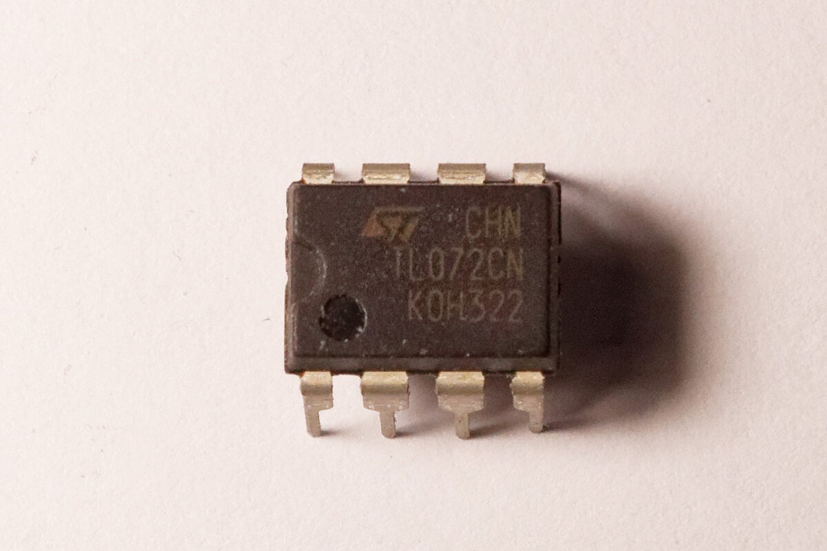 Circuito integrado TL072CN em encapsulamento DIP de 8 pinos sobre fundo claro