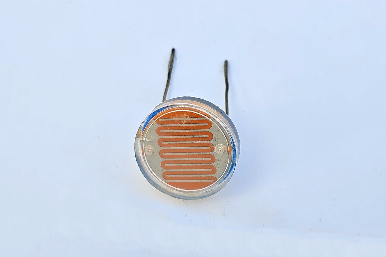 Sensores: fotorresistor LDR de 25 mm com a trilha serpentina laranja de sulfeto de cádmio visível sob a janela de vidro