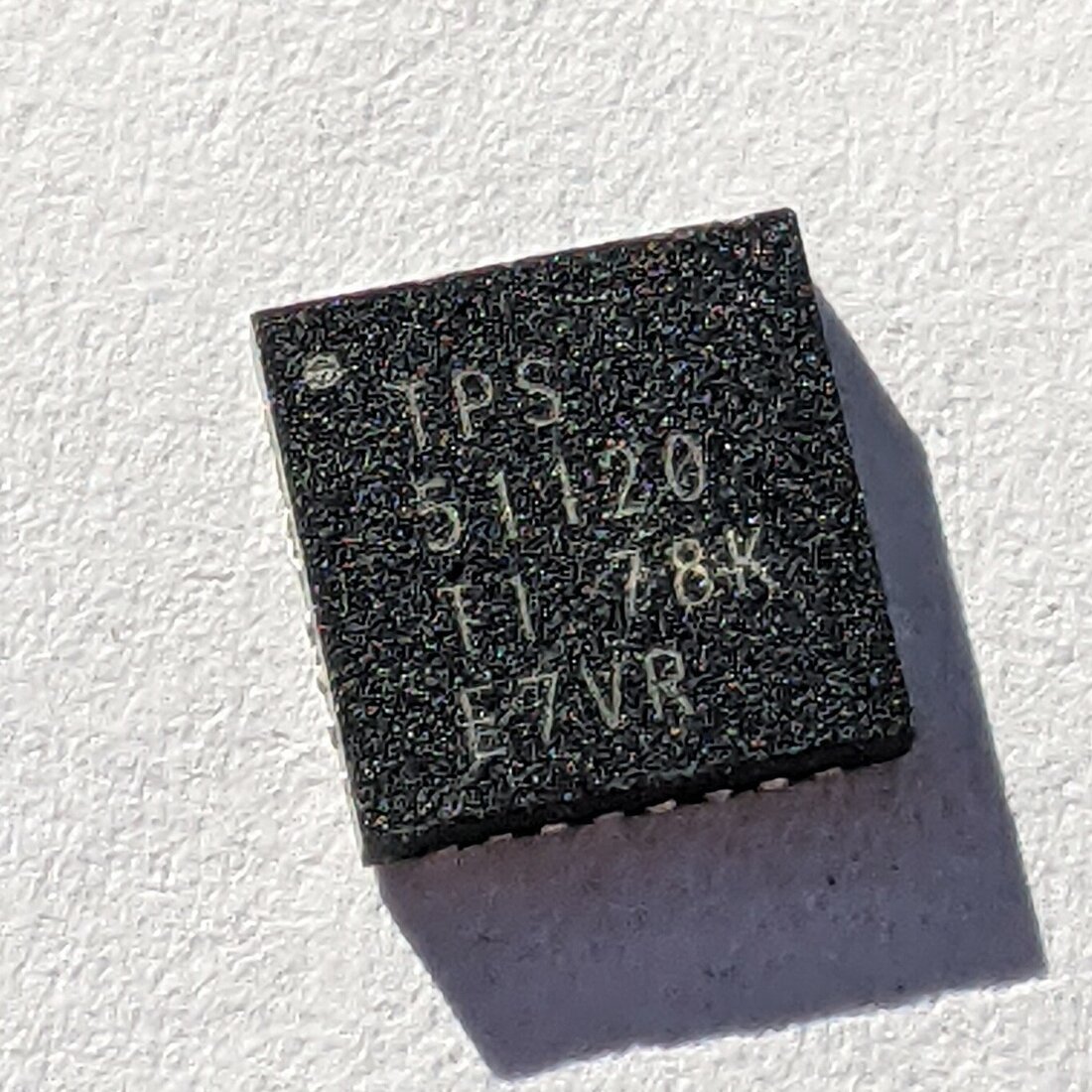 Chip QFN de gerenciamento de energia visto de cima, sem nenhum terminal aparente nas laterais