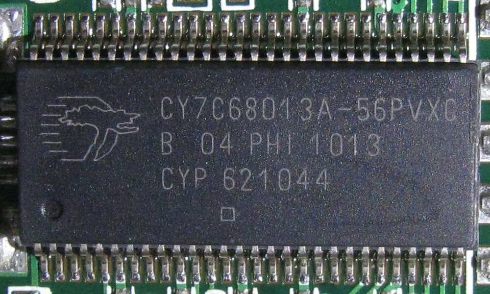 Close da marcação de um chip Cypress CY7C68013A em encapsulamento SSOP de 56 pinos soldado numa placa verde