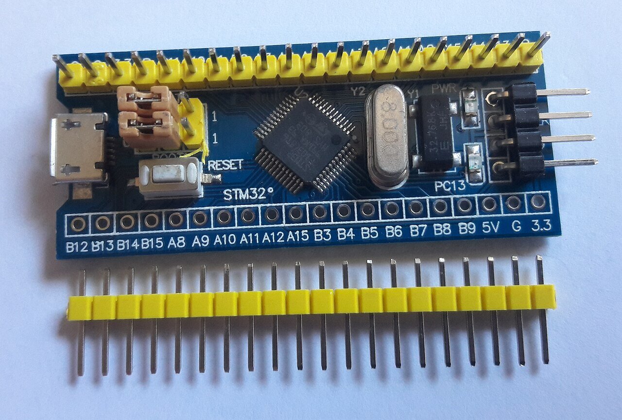 Placa azul com microcontrolador STM32F103C8T6, mostrando à direita o conector de quatro pinos usado para a gravação por SWD