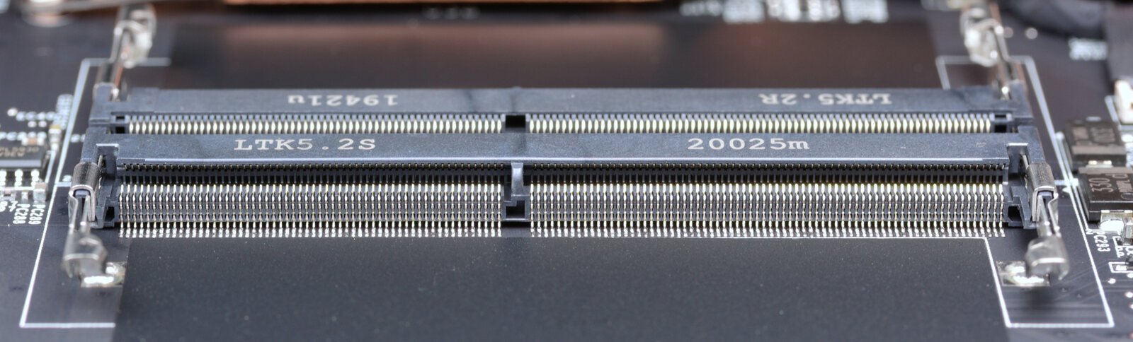 Dois slots SO-DIMM DDR4 vazios em uma placa-mãe de notebook, vistos de cima, com as travas laterais